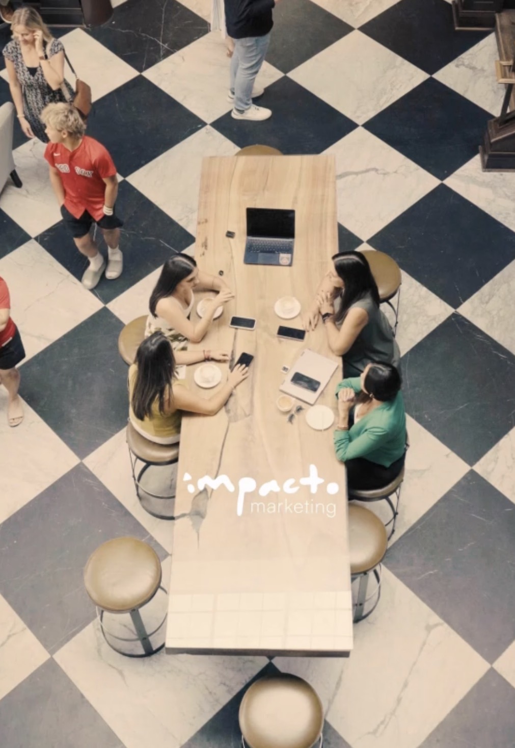 The Impacto Marketing team sharing ideas around a table.